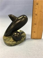Contemporary soapstone carving of whales mounted o