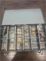 A variety of coins in a metal tin.