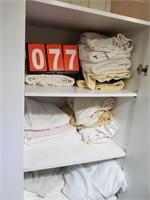 Bedding and towel lot in hallway cabinet