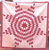 A handmade red and white quilt with