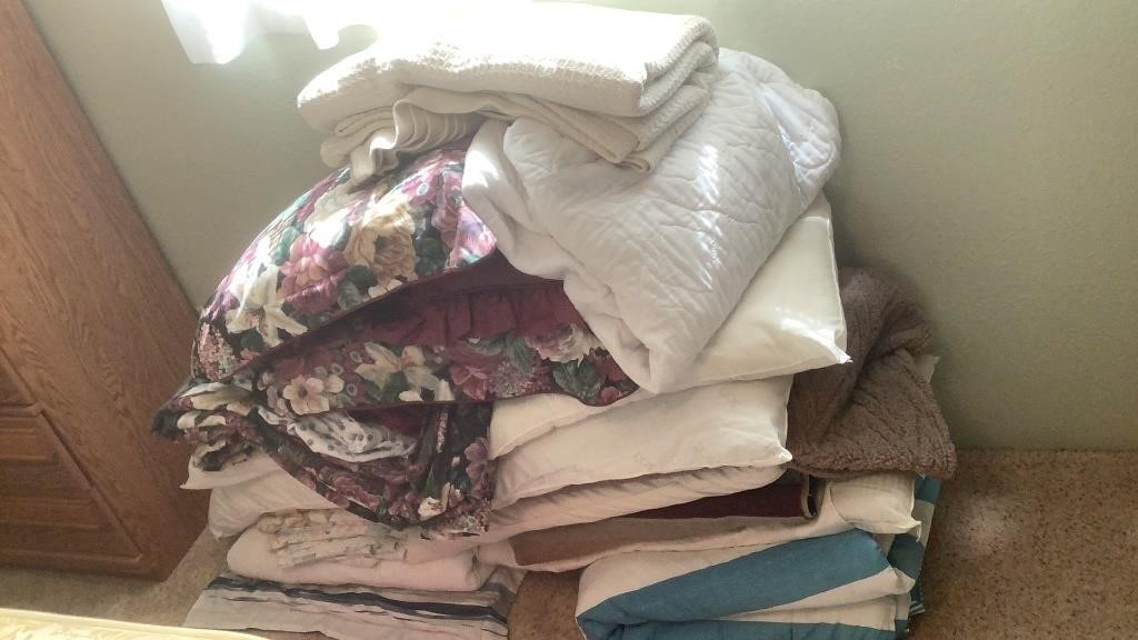 Stack Of Misc Bedding In Spare Bedroom