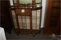 Vintage bow front display cabinet with clock.