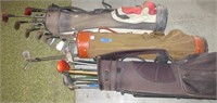 3 golf bags with clubs