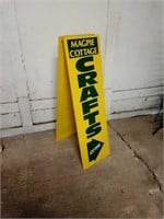 Bi-fold wooden sign, painted yellow. Could be
