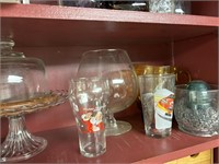 shelf of glass cake plate, bowls, hurricanes, vase