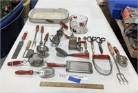 Red handled kitchen utensils, white enamel pan &