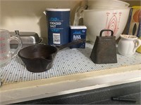 Shelf contents including cowbell and cast iron