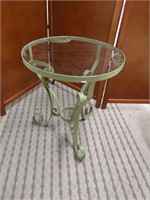 Patio side table with a metal base and glass top.