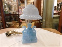 blue glass lamp, woman on bench w shade