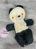 Vintage stuffed panda bear with yellow eyes