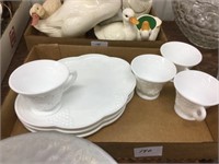 Four milk glass snack plates with tea cups