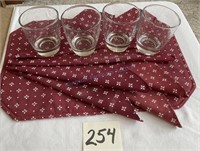 Four heavy short, drinking glasses, placemat, and