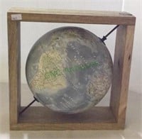 World globe suspended in wooden frame. Frame is