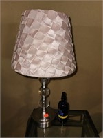 Small lamp and glass top table, king size bed