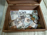 Wooden box with paper money and coins inside.