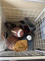 Basket with basketballs and footballs and