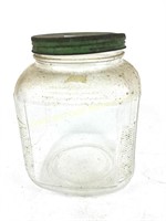 Glass jar with green lid.