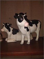 Two porcelain cows one broken horn