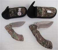 (2) Buck camo pocket knives with belt cases.