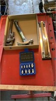 Pipe wrench, hammer, hand sander, drill bits.