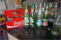 Collection of Various Glass Bottles in Paper Coke