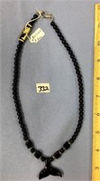 Black bead necklace with a baleen whale's tale, 20