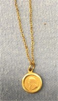 Small gold krugerrand in a bezel on a gold tone ch