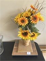 Sunflower arrangement in pottery vase with wood