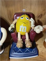 yellow M&M in recliner with TV remote and