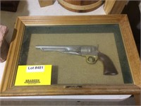 Carving of revolver in shadow box