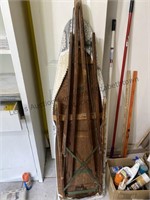 Wood ironing board, brooms and yard sticks