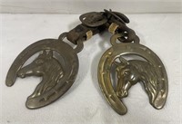 Vintage brass horse medallions on leather strap.
