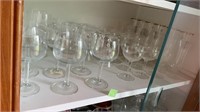 Shelf of misc wine glasses some may be chipped
