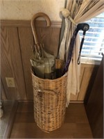 Umbrella basket with umbrellas and a cane