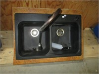 Double kitchen sink with faucet .
