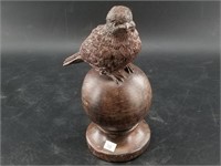 Heavy resin carving of a bird atop a ball 8 3/4"