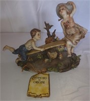 Vintage boy and girl on seesaw figurine