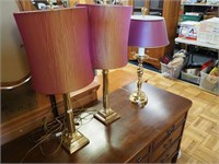 Three brass lamps: pair of matching with red
