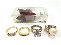 4 costume jewelry rings plus a rose brooch
