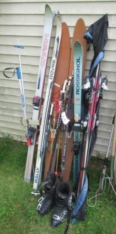 Large group of various snow skis with poles and