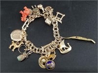 Heavy gold charm bracelet, consisting of 10kt-18kt