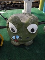 Concrete frog eating a bug statue