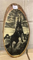 Black stallion horse on log