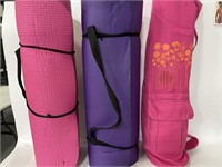 Trio of pink and purple yoga exercise mats