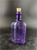 Antique manganese glass bitters bottle with cork,