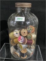 Vintage pickle jar with wood thread spools