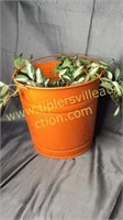 Orange metal bucket with greenery