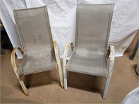 2 metal framed tan lawn chairs