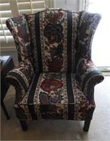 Floral upholstered wingback chair with stretcher
