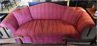Red upholstered camelback sofa